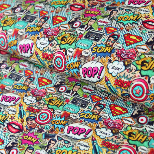 Bunter Baumwolljersey mit Comic-Pop-Art-Motiven, Superman-Logo, Sprechblasen und Lippen in kräftigen Farben.