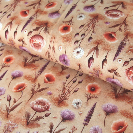 Baumwolljersey in Beige mit zarten Feldblumen und Kräutermotiven in Rot, Lila und Weiß.