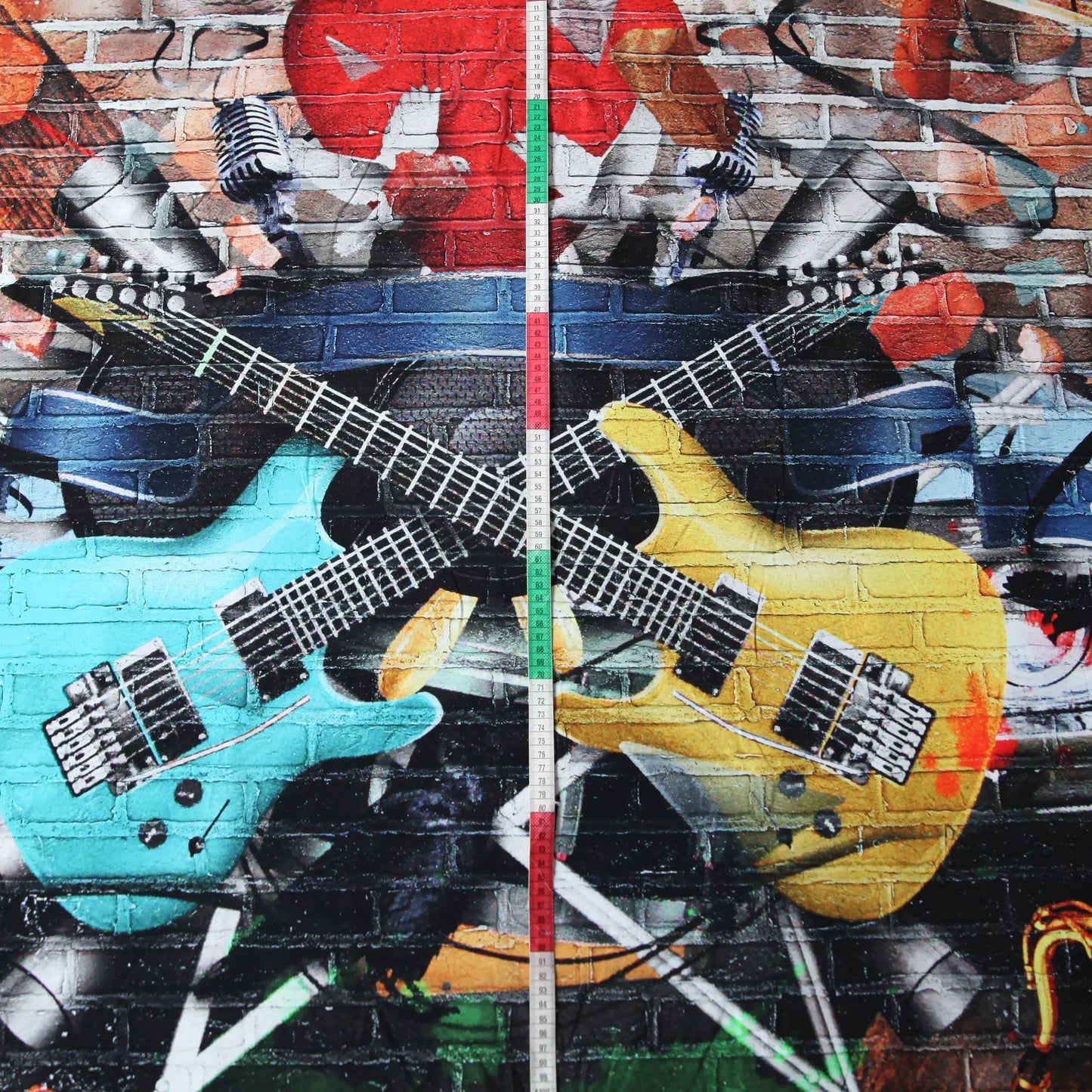 Baumwolljersey mit blauem und gelbem E-Gitarren-Motiv vor Graffiti-Hintergrund.