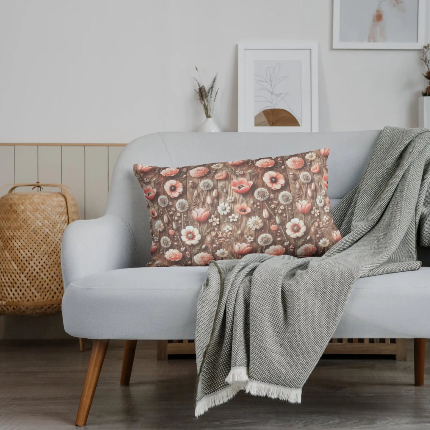 Beiges Baumwolljersey mit Pusteblumenmuster auf grauem Sofa mit grünem Wollplaid und Holzrahmen.