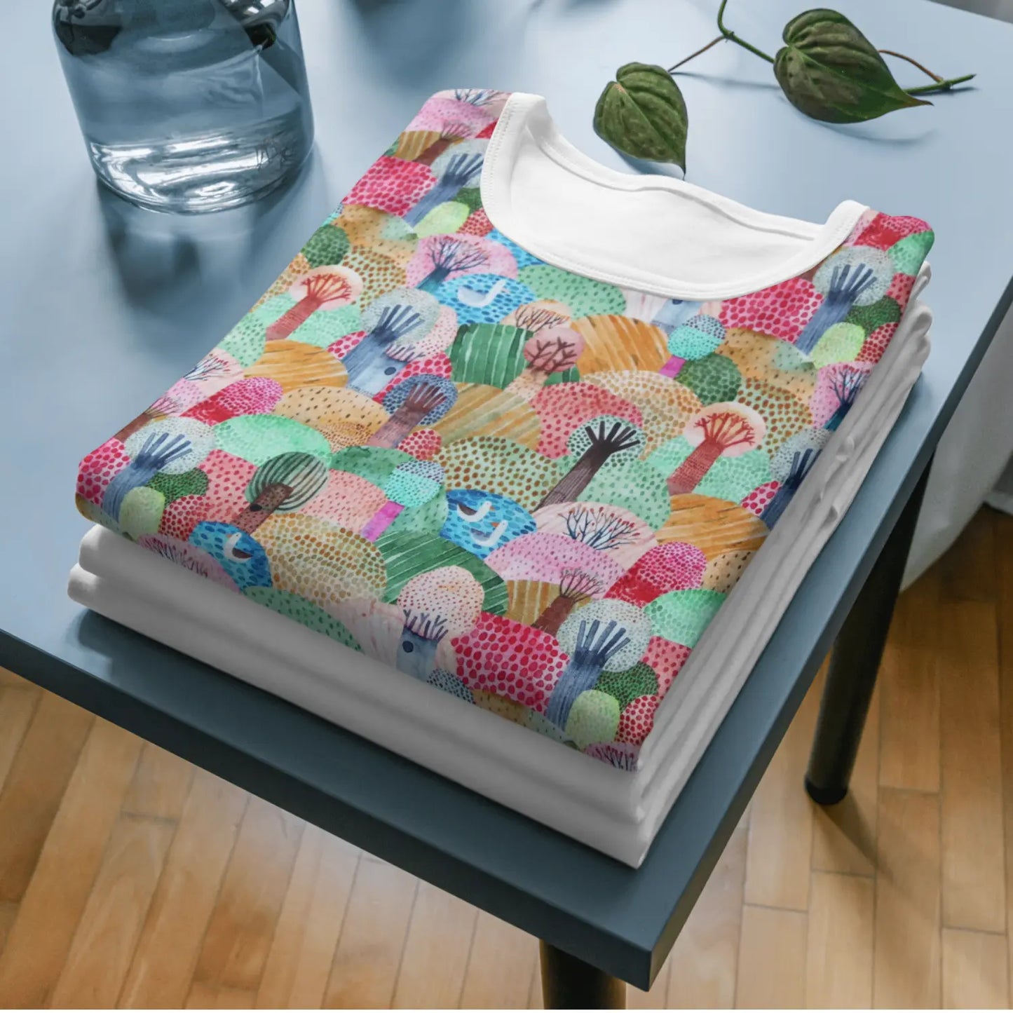 Gefaltetes Baumwolljersey-Shirt mit buntem, abstraktem Baum-Muster auf hellem Grund.